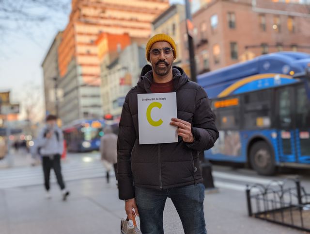 Jas Singh of Brooklyn holds up a letter grade assessing Mayor Bill de Blasio's record: a "C".